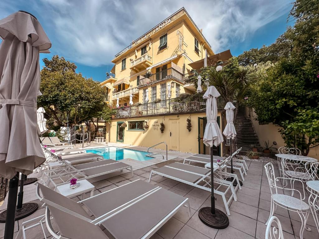 圣玛格丽塔-利古雷阿尼塔别墅酒店的一座带游泳池和椅子的酒店和一座建筑