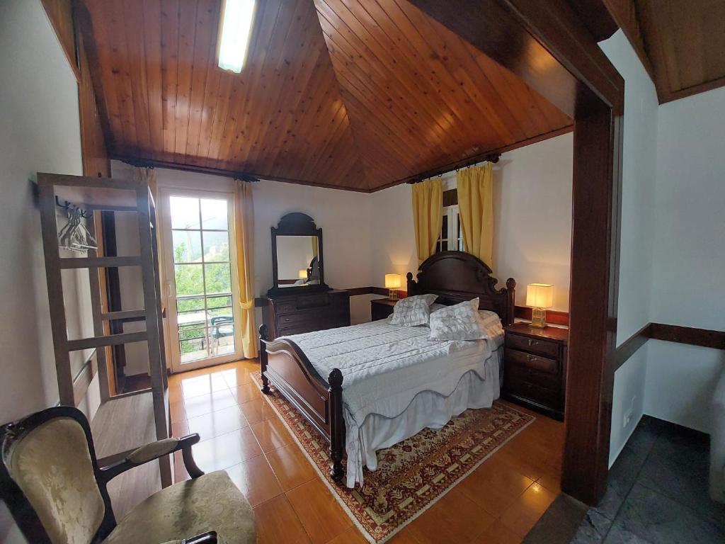 Faial3A Botanical Dimensions Nature Terraces BBQ的一间卧室设有一张床和木制天花板