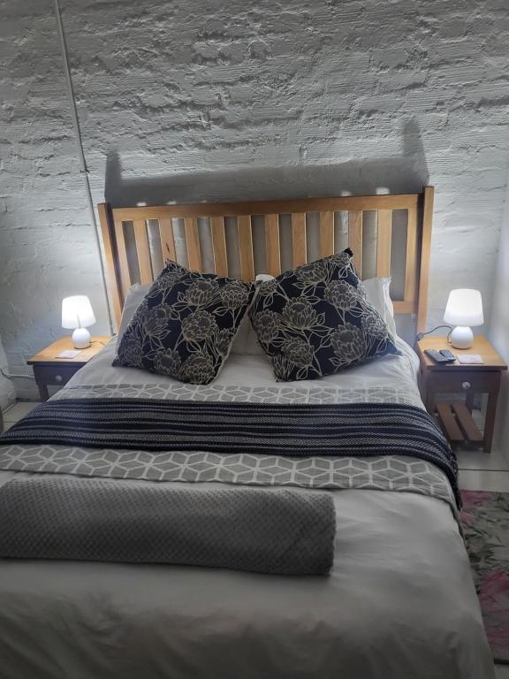 开普敦9 on Oostersee的一间卧室配有一张带枕头的床和两盏灯。