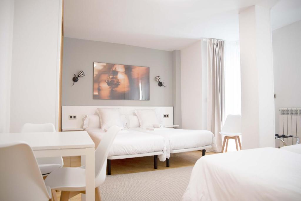 圣地亚哥－德孔波斯特拉Stellae Luscofusco的白色的客房配有两张床和镜子