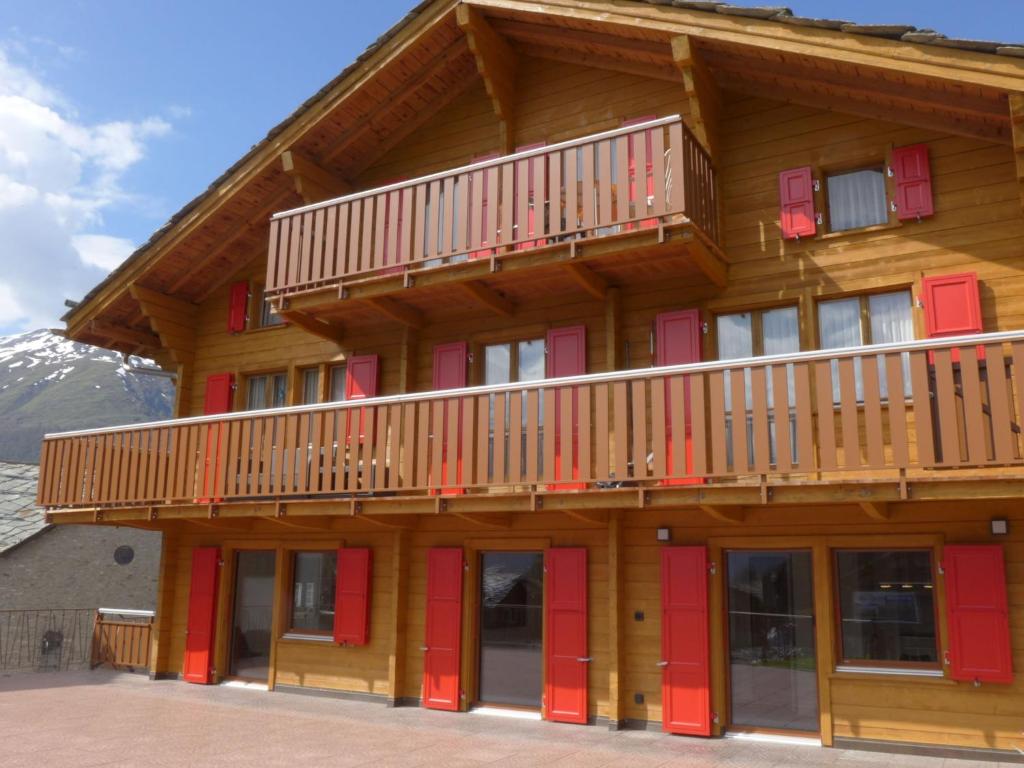 格雷兴Apartment Wiedersehn Dachgeschoss by Interhome的一座带红色门和阳台的大型木制建筑