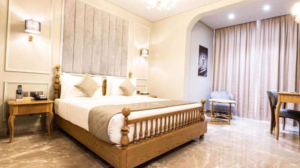迪拜总统酒店的一间卧室配有一张床、一张桌子和一把椅子