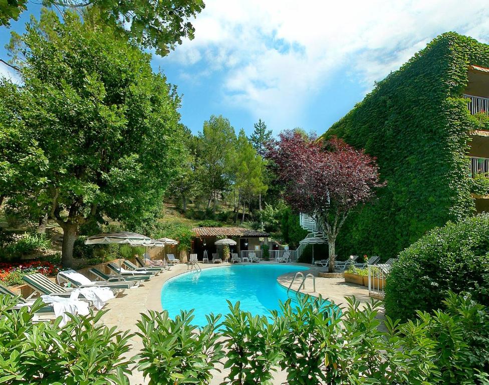 格雷乌莱班Villa Borghese, The Originals Relais的一座带椅子和树木的游泳池以及一座建筑