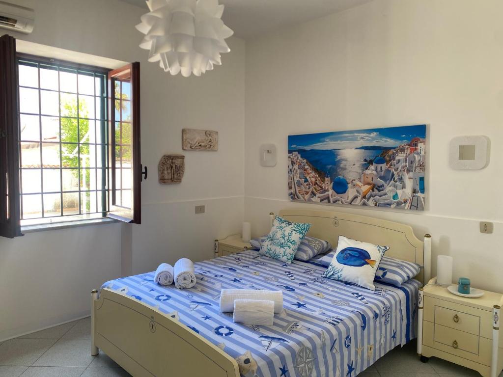 圣费利切-奇尔切奥Villa Nausicaa San Felice Circeo的卧室配有一张床,墙上挂有绘画作品