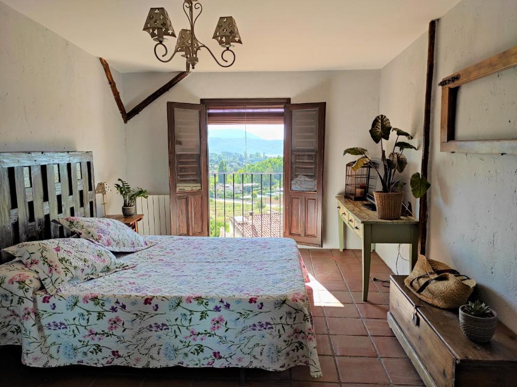 DurónCasa Rural El Botánico的一间卧室设有一张床、一个窗口和一张桌子