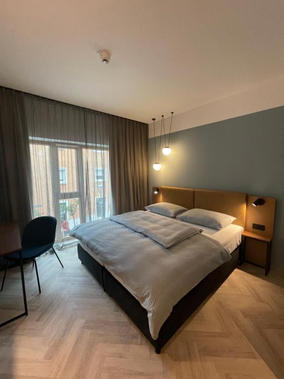 诺伊马克特Stadthotel Neumarkt Mitte的一间卧室配有一张大床和一把椅子