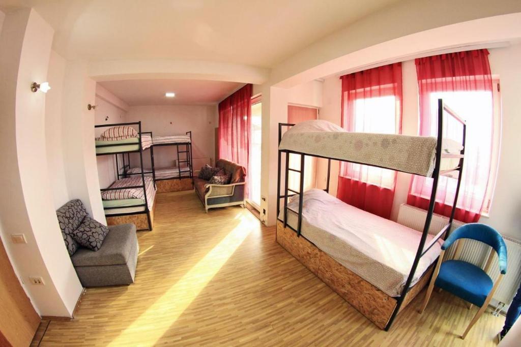 奥赫里德Golden Age Hostel的带两张双层床和椅子的房间