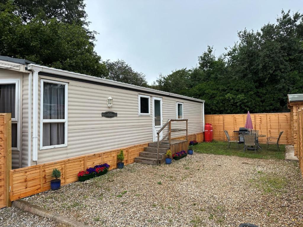 普里茅斯Static Caravan - Plymouth - Costal Location的移动房屋设有围栏和庭院。