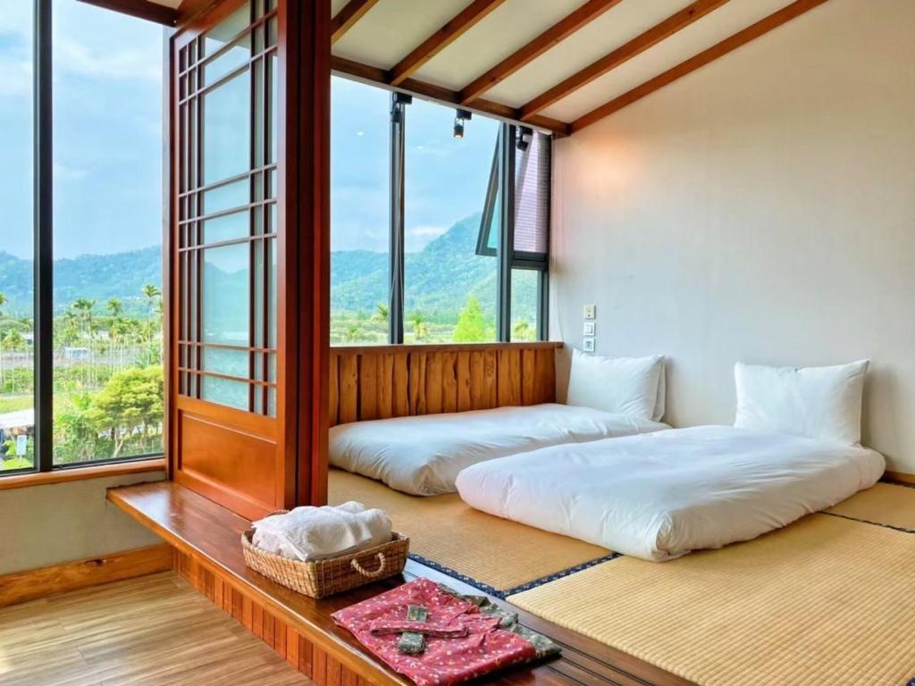 鱼池乡散步的云-日月潭生态民宿的带大窗户的客房内的两张床