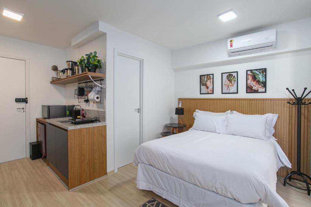 圣保罗MOL - Liberdade - Anora Spaces Residenciais的一间带白色床的卧室和一间厨房