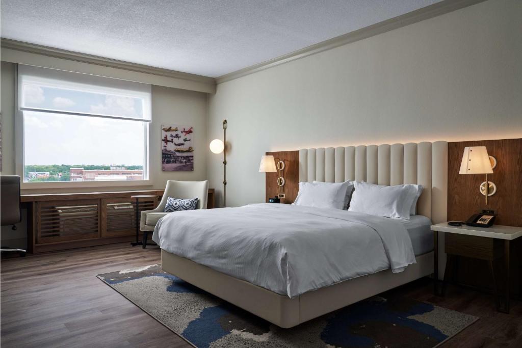 达拉斯达拉斯 - 爱田希尔顿逸林酒店的一间卧室设有一张大床和一个窗户。
