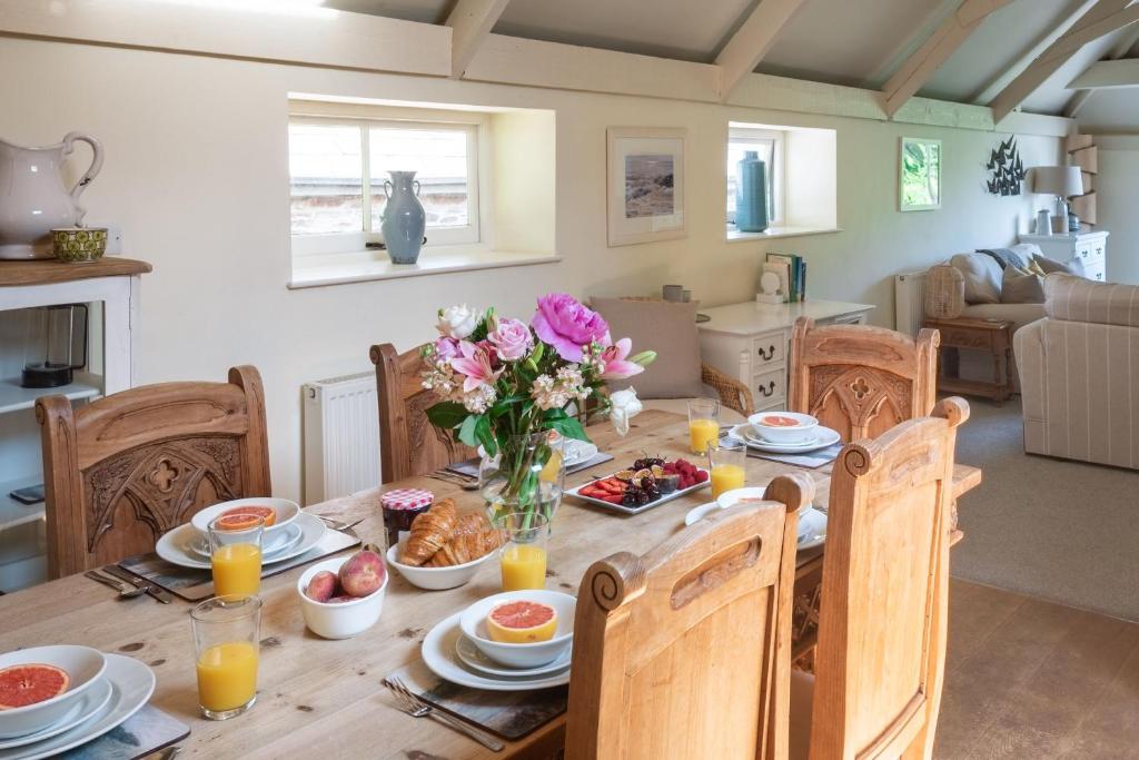 金斯布里奇Twysden Cottage的餐桌上摆放着食物和鲜花