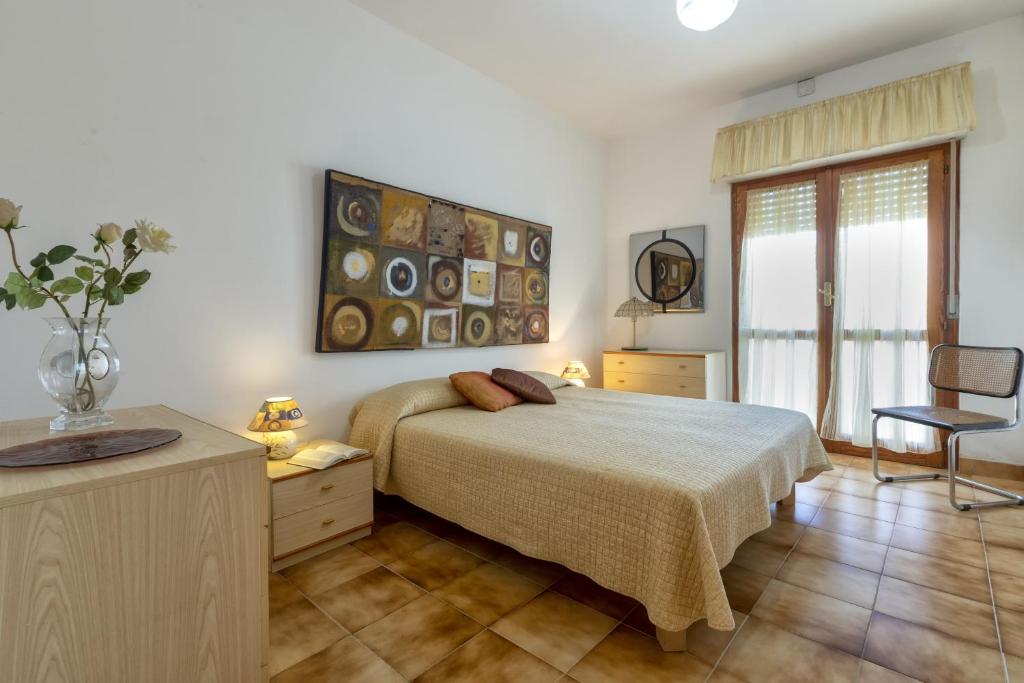 萨萨里Villa Brandinu的一间卧室配有一张床、一张桌子和一把椅子