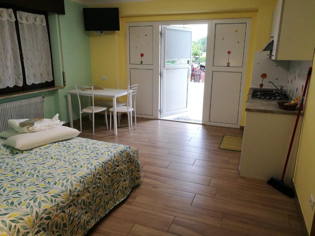 CesiomaggioreColori nel Parco 2的一间卧室配有一张床,厨房配有桌子