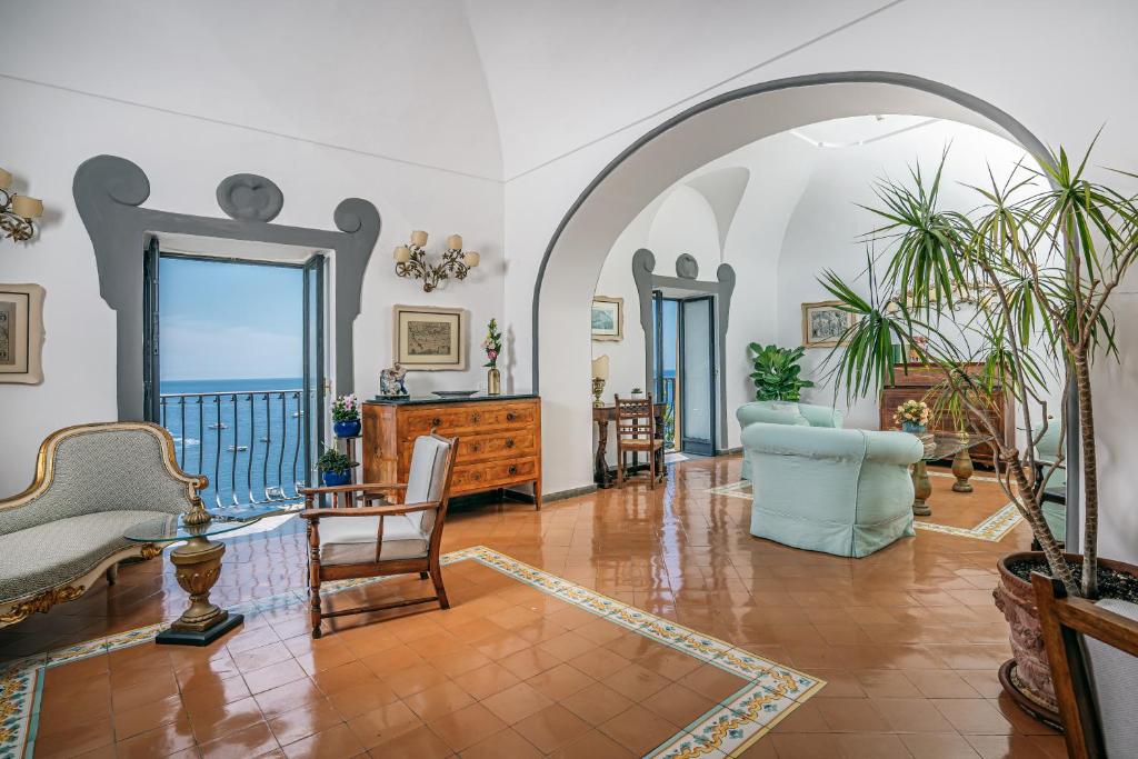 波西塔诺Albergo Miramare Positano的一个带桌椅的客厅的拱门