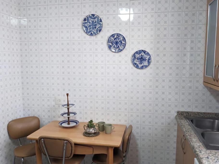 马贝拉Luminosa casa familiar céntrica的厨房配有桌子和墙上的蓝色盘子
