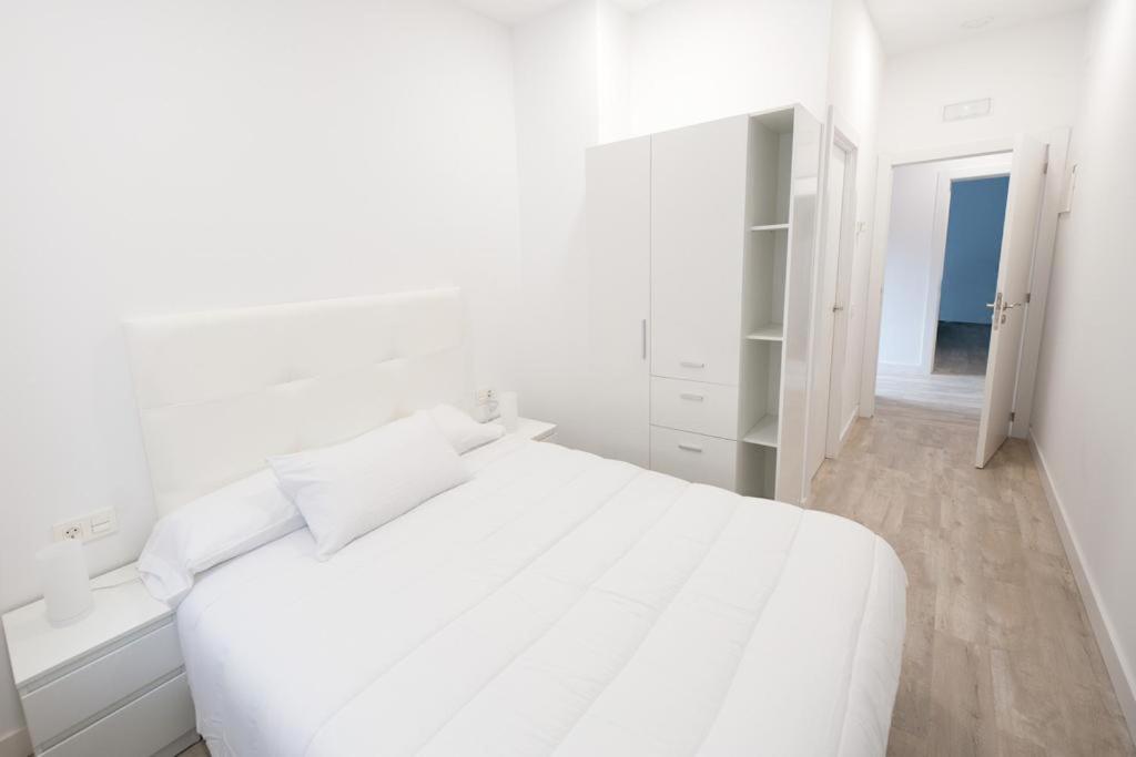 圣塞瓦斯蒂安Pension MD的白色的卧室配有白色的床和镜子