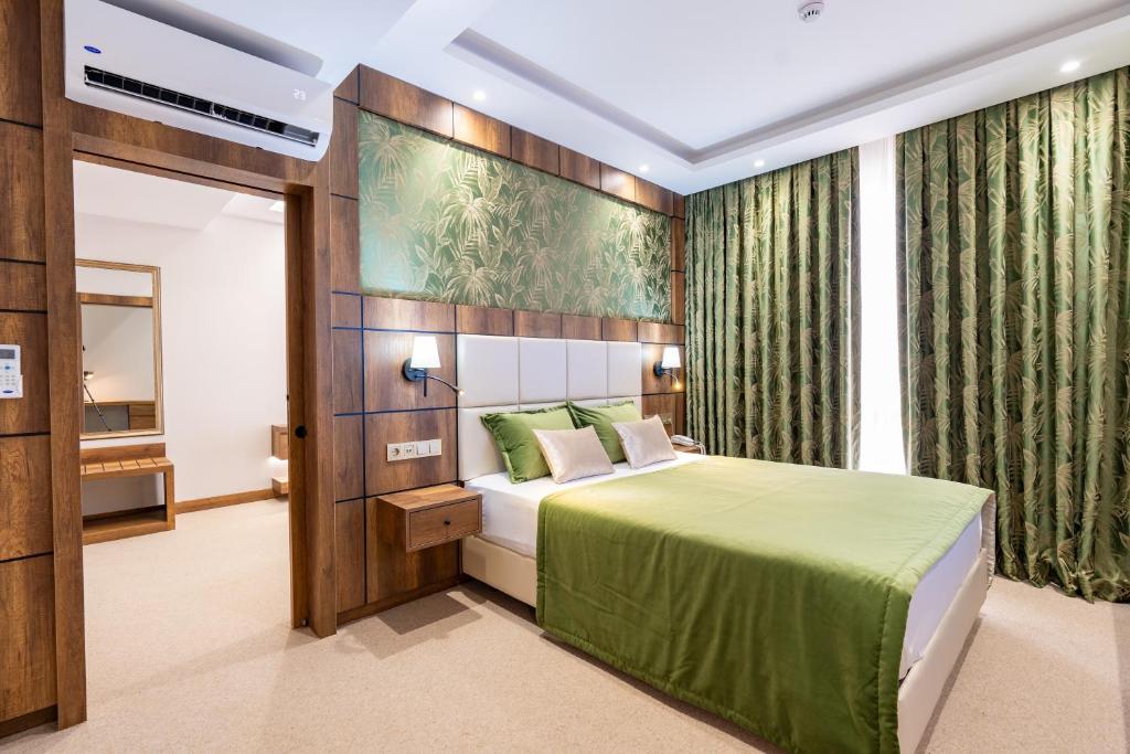 伊斯坦布尔Mardy Suit Hotel的一间卧室设有一张绿色的床和一个窗户。