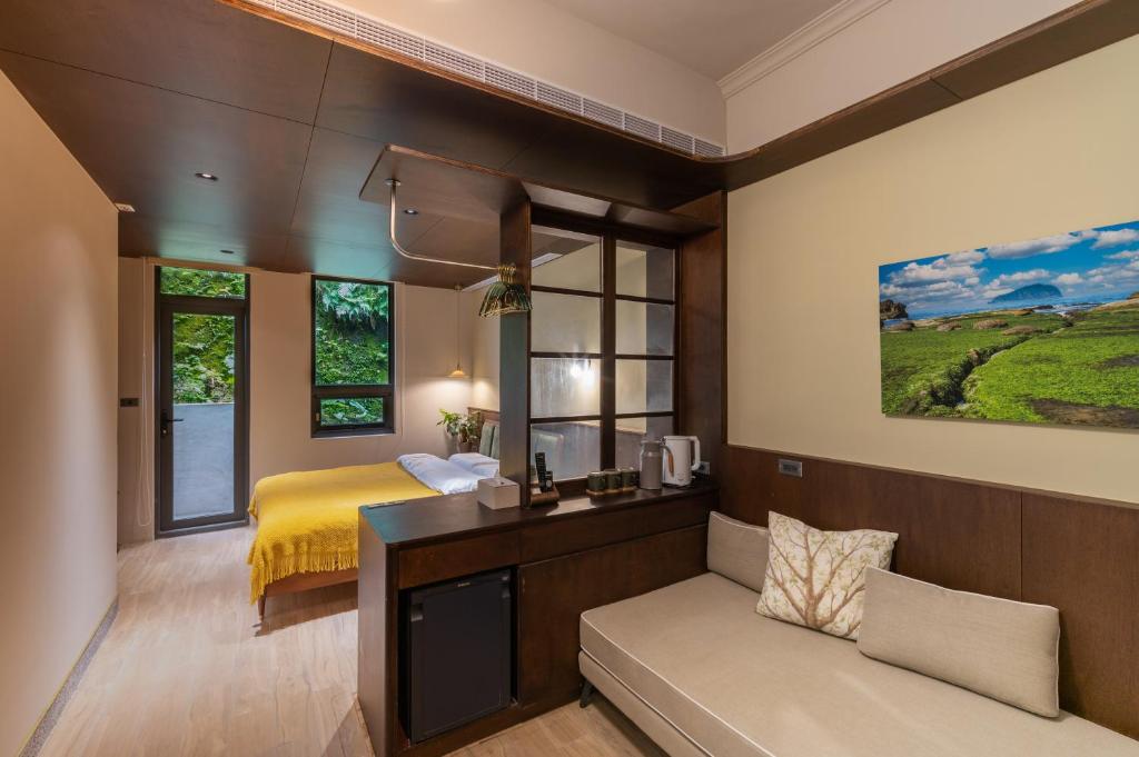 基隆安樓文旅Enzo House的一间卧室配有一张床和一个沙发