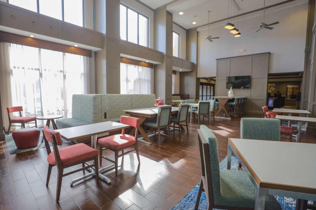 贝城Hampton Inn & Suites Bay City的用餐室设有桌椅和窗户。
