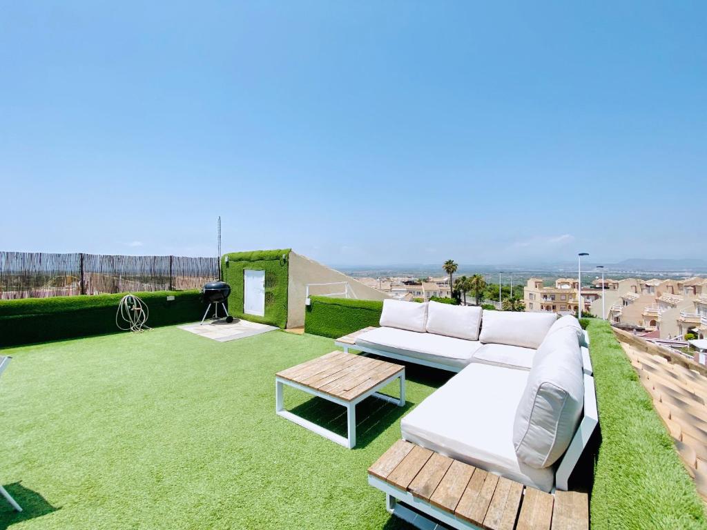 格兰阿利坎特Casa Natura Sunset Beach的一个带白色沙发和一张桌子的庭院