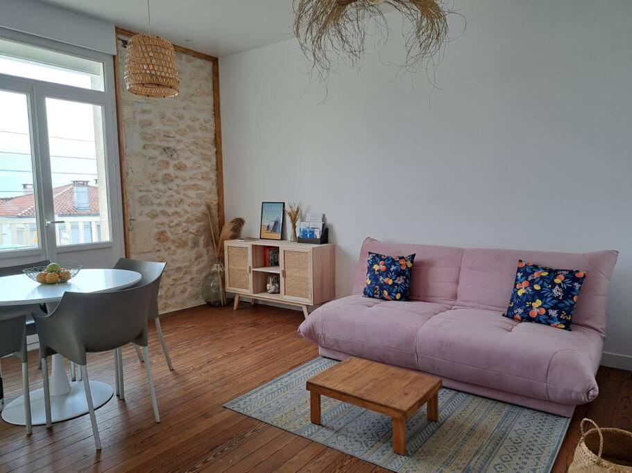 鲁瓦扬Appartement, Royan. Proche plage.的客厅配有紫色沙发和桌子