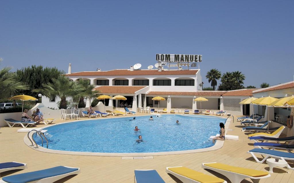 珀彻斯Albergaria Dom Manuel Hotel的一个带躺椅的大型游泳池和一间酒店