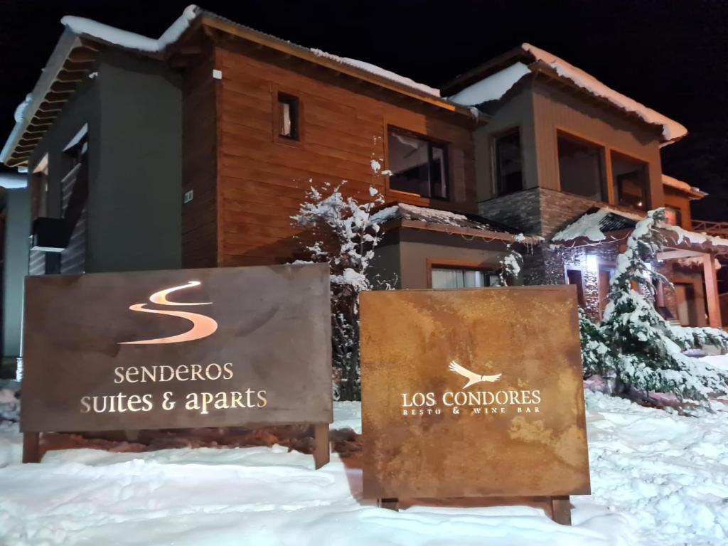 厄尔查尔坦Senderos Aparts & Suites的房屋前雪中的标志