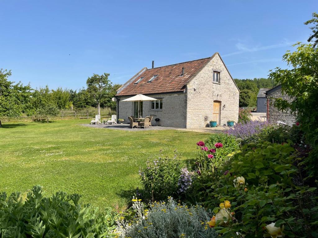 谢普顿马利特Yew Tree Cottage的前方带花园的石头小屋