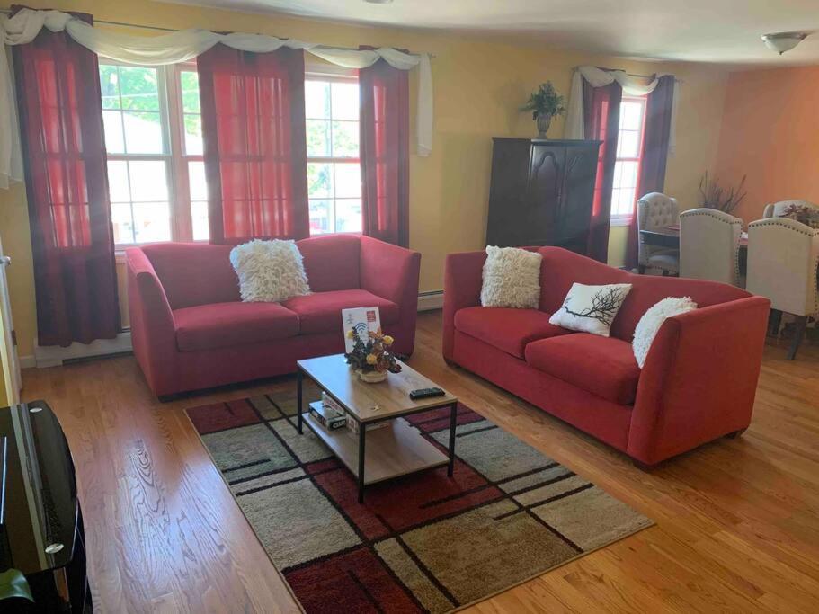 伊丽莎白Family 3-bedroom home (2nd floor near EWR/Outlet)的客厅配有2张红色沙发和1张咖啡桌