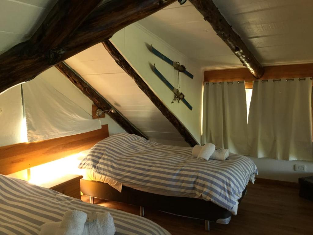 特来凡林Charret Trevelin的一间卧室设有两张床,墙上挂着一个时钟。