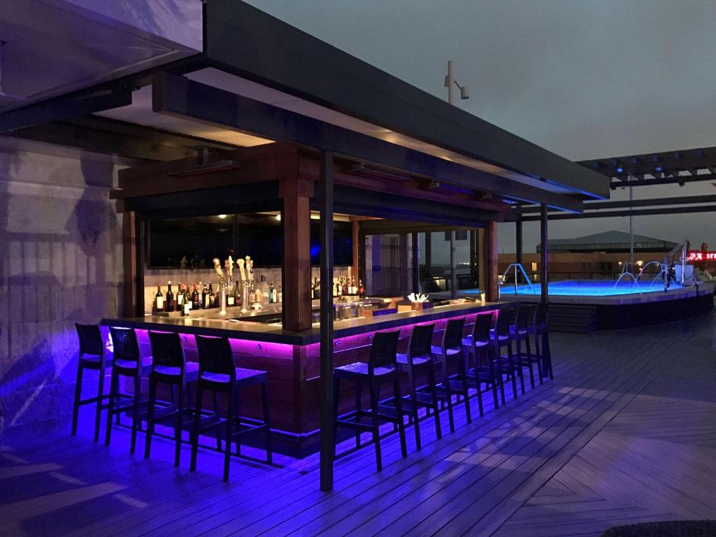 萨凡纳萨凡纳历史区霍姆/滨河伍德套房酒店的甲板上的酒吧,拥有紫色的灯光