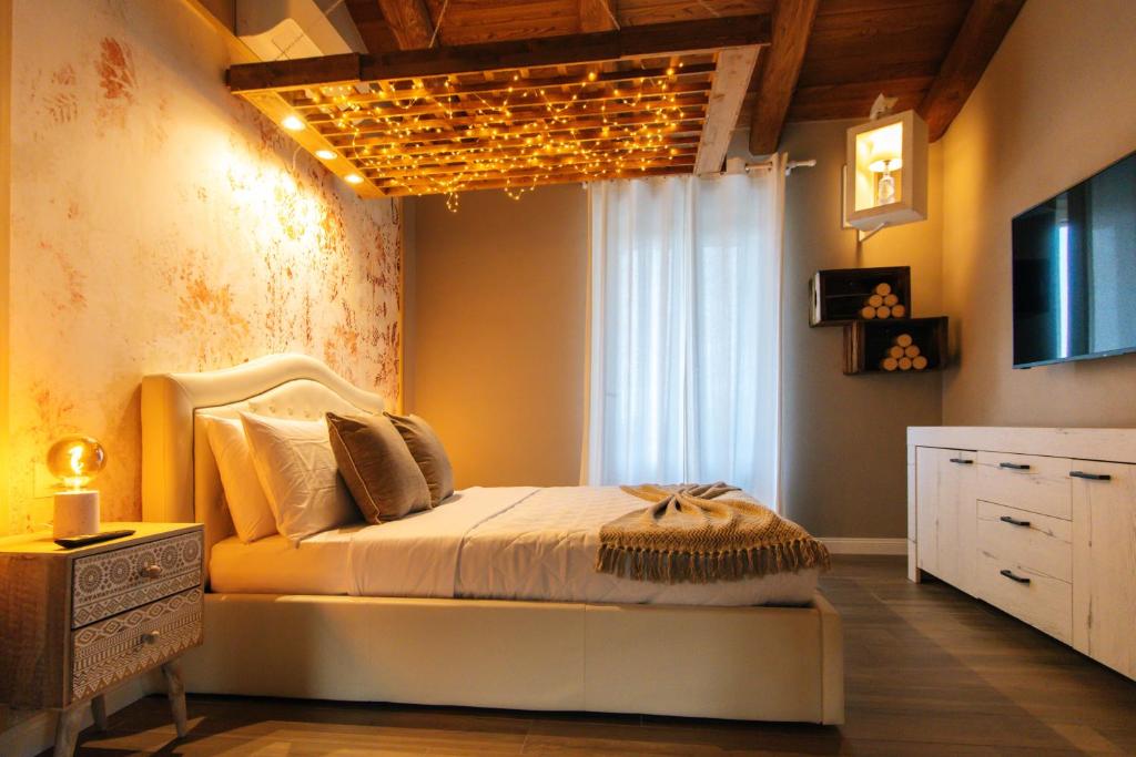 萨卢佐Agriturismo Agli ulivi的一间卧室配有一张天花板上吊灯的床。