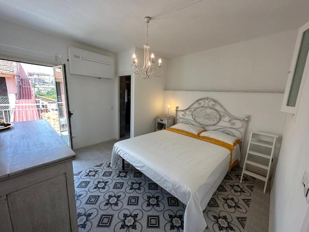 莱里奇Favolosa stanza gialla con terrazzino vista mare Mottino23的一间带一张床的卧室和一间带吊灯的厨房
