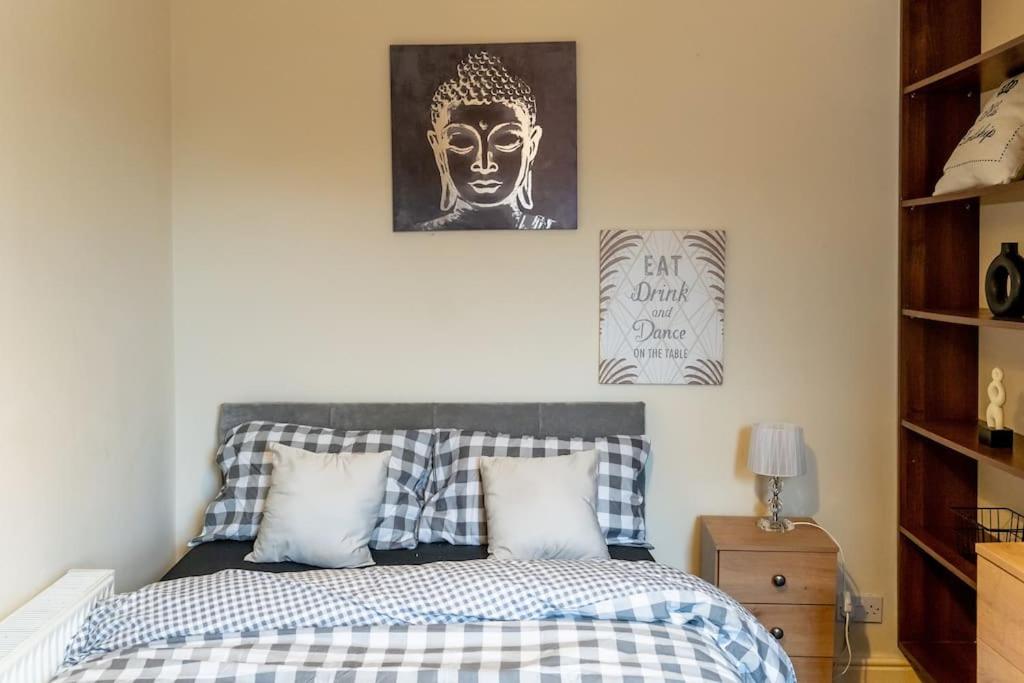 曼彻斯特Amazing Entire 4 Bedroom Home的一间卧室配有一张床和一张雕像的照片