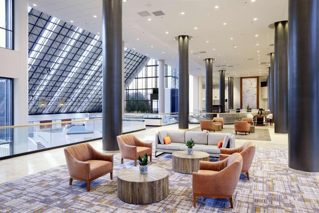 达拉斯达拉斯商业街双树酒店的大堂配有沙发、桌子和窗户。