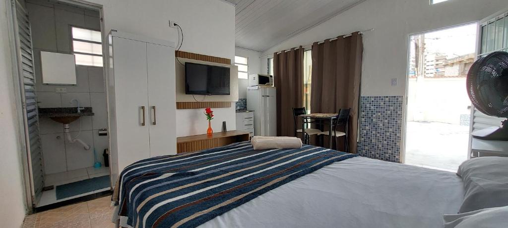 大普拉亚Pousada Aconchego Ocian的卧室配有一张床,墙上配有电视。