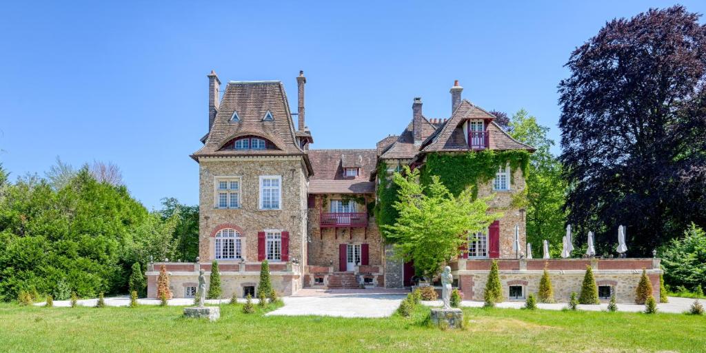 巴比松Le Petit Château de Barbizon au Bois du Mée的一座在田野顶部有塔的老房子