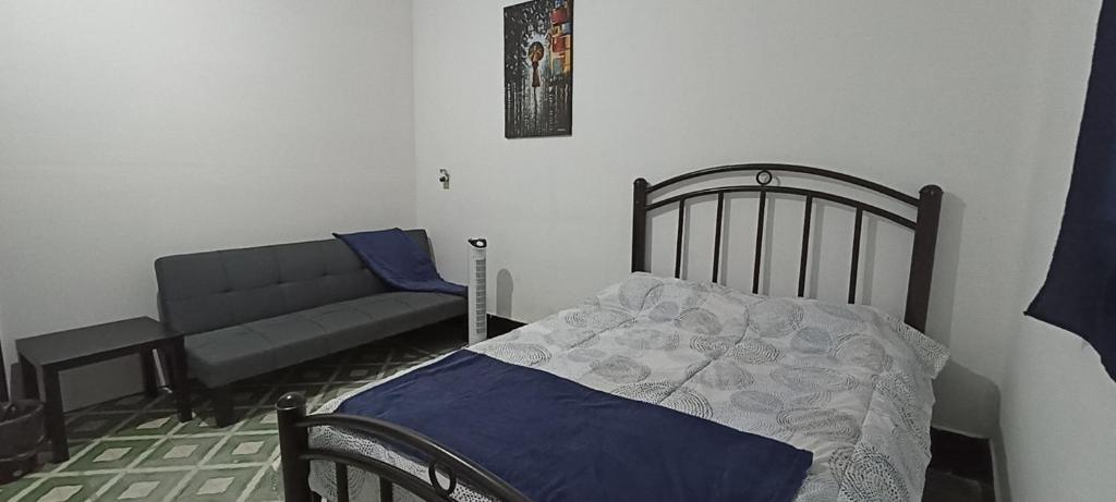 奥里萨巴Hostal Casa Azul, sencilla的一间卧室配有一张床和一张沙发