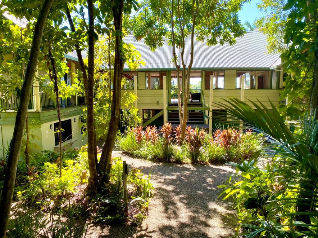 米申海滩Jackaroo Treehouse Rainforest Retreat的黄色的房子,前面有一个花园