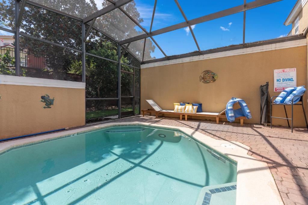 基西米Wish Upon A Splash - Family Villa - 3BR - Private Pool - Disney 4 miles的一座带玻璃屋顶的建筑中的游泳池