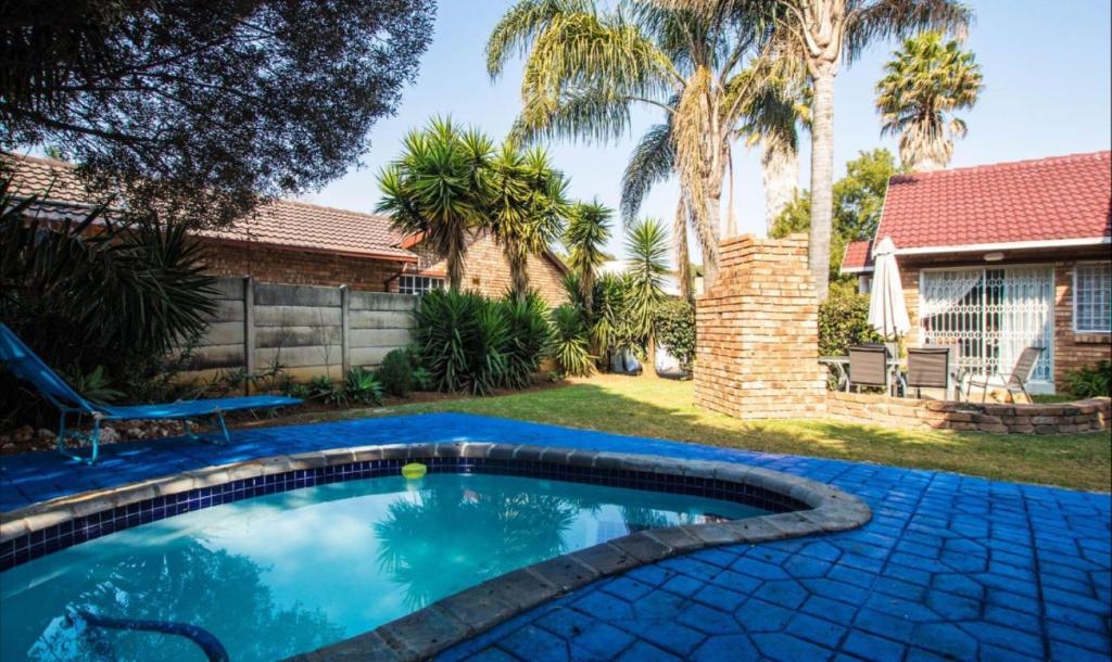 肯普顿帕克The Link on Bonsai的棕榈树房子后院的游泳池