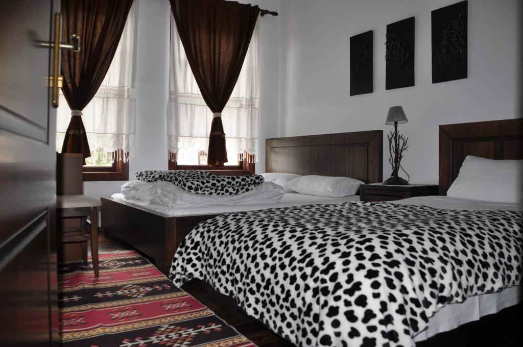 培拉特贝尔格莱德曼加林酒店的一间卧室配有两张黑白床单