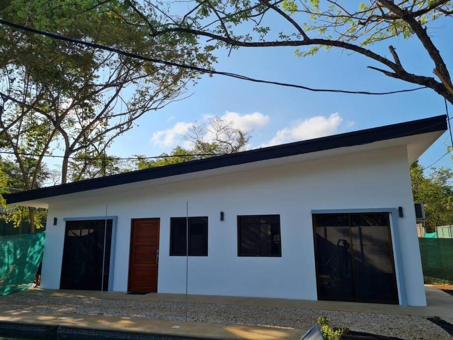 塔马林多Casa Mar de Sueños Tamarindo的黑色屋顶的白色房子