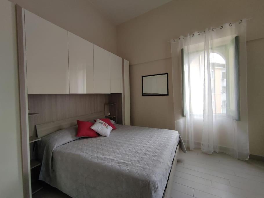 马奥莱La Torre的一间卧室配有一张带红色枕头的床和一扇窗户