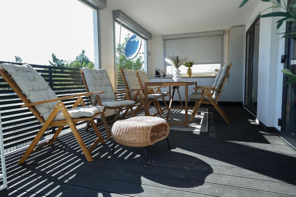 洛瓦尼斯卡Mobile home Mare Blu的露台配有椅子和桌子,甲板上配有桌子