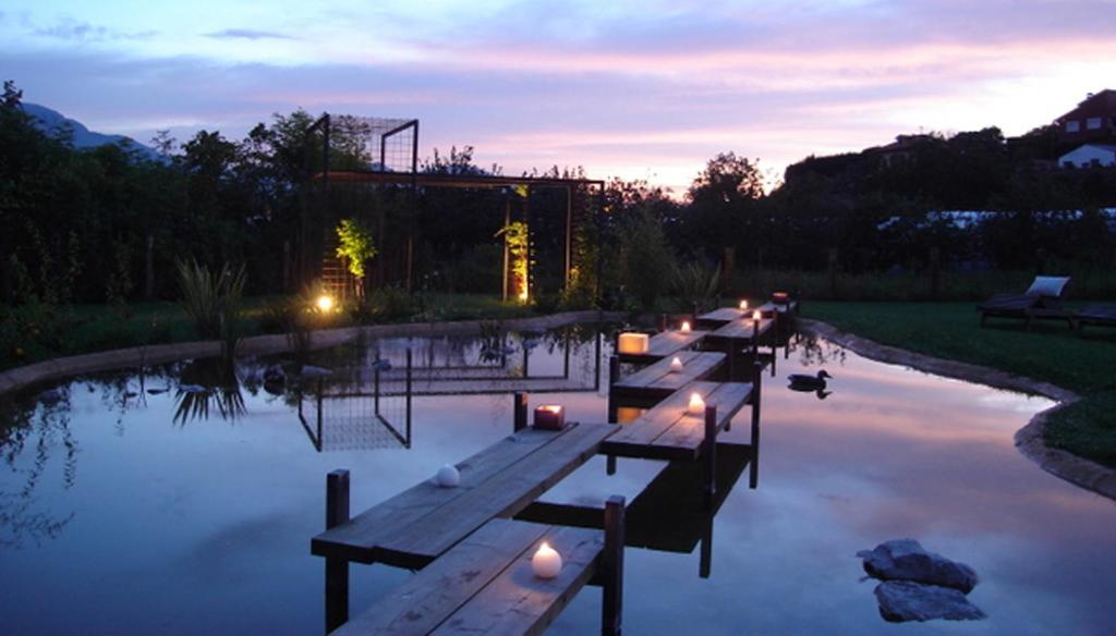 利亚内斯克尤别墅公寓式酒店的黄昏时在池塘里排长椅