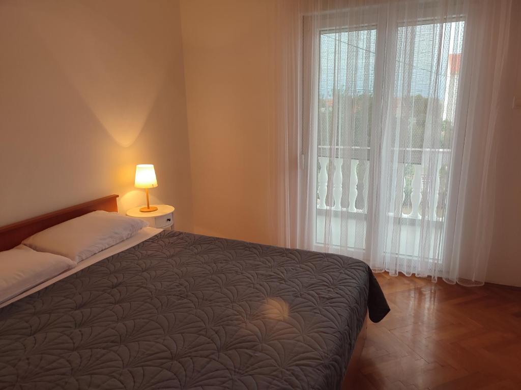 波弗加纳Povljana Maris的一间卧室设有一张床和一个大窗户