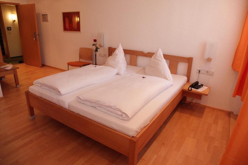 黑尔斯布鲁克Gasthof Hotel Bauer的一张带白色床单和枕头的床