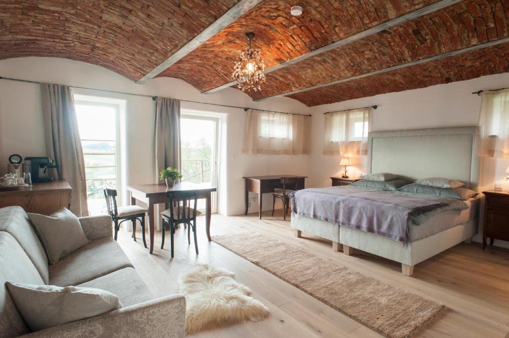Sankt Andrä-HöchAm Pfarrhof - Gourmethotel by Harald Irka的一间卧室配有一张床、一张沙发和一张桌子